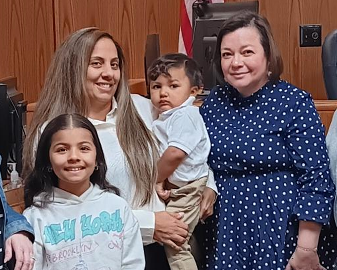 Melissa (right) with a family at their adoption hearing